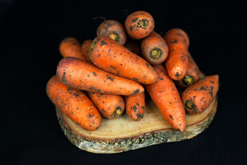 Fresh carrots on a black background, farm organic vegetables