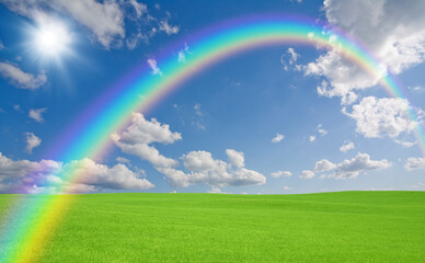 Obraz na płótnie Canvas 緑の草原と雲と虹と太陽