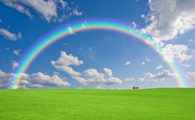 Naklejka premium 草原の赤い屋根の家と雲と虹