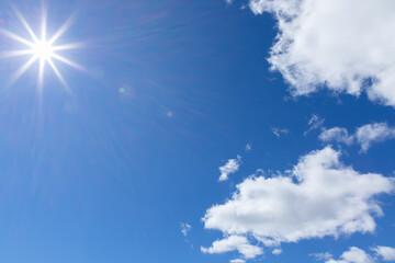 Naklejka na ściany i meble The rays of the sun on blue sky with cumulus clouds