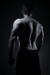 Fototapeta na wymiar Rear view of young muscular man in black and white. Nude silhouette