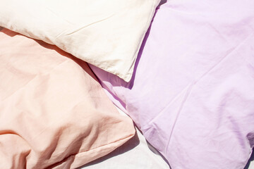 Three pillows, lavender, peach and white. Bed textiles