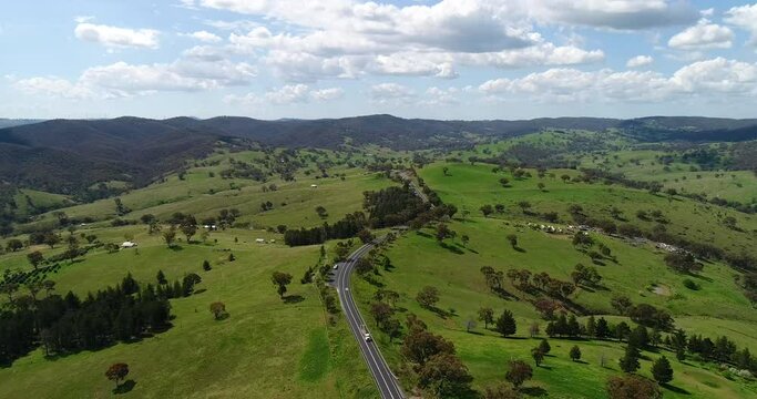 Highway road between farms and green pasture hill ranges in NSW as 4k.
