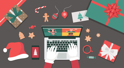 Obraz premium Concept of Santa Claus hand using a laptop video call to people for Christmas holiday celebration top view table with gifts, cookies, candy, Santa hat, and postcard, vector flat lay illustration
