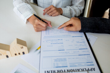 Close up of Hands Business woman signature on contract to buy or sell real estate.