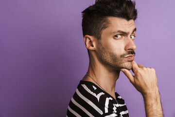 Photo of thinking young man posing and looking at camera