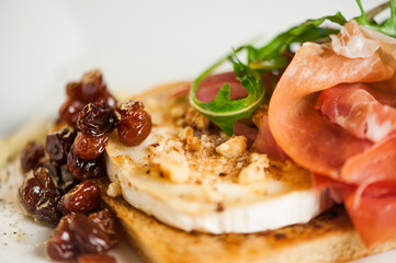 Light fresh delicious italian dish closeup with chevre prosciutto walnuts and raisins
