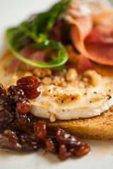 Light fresh delicious italian dish closeup with chevre prosciutto walnuts and raisins
