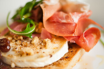 Light fresh delicious italian dish closeup with chevre prosciutto walnuts and raisins