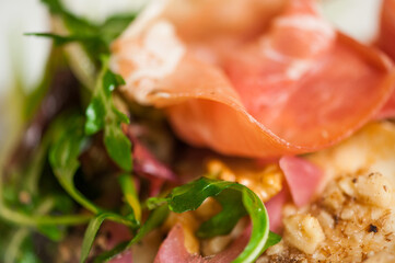 Light fresh delicious italian dish closeup with prosciutto walnuts and salad