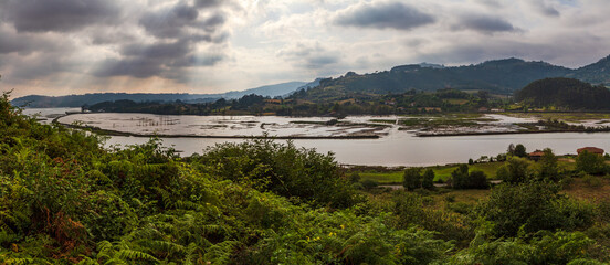 Panoramica de nubes y rayos de sol en una ria de las costa asturiana