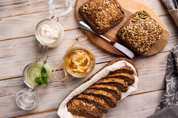 Different spreading sauces in jars with cut  bread