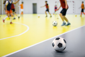 Indoor futsal soccer players playing futsal training. Indoor soccer sports hall. Futsal players kicking ball. Futsal training dribbling drill. Sports background. Indoor soccer league