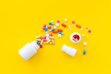 Medical pills and tablets spilling out of bottle, copy space