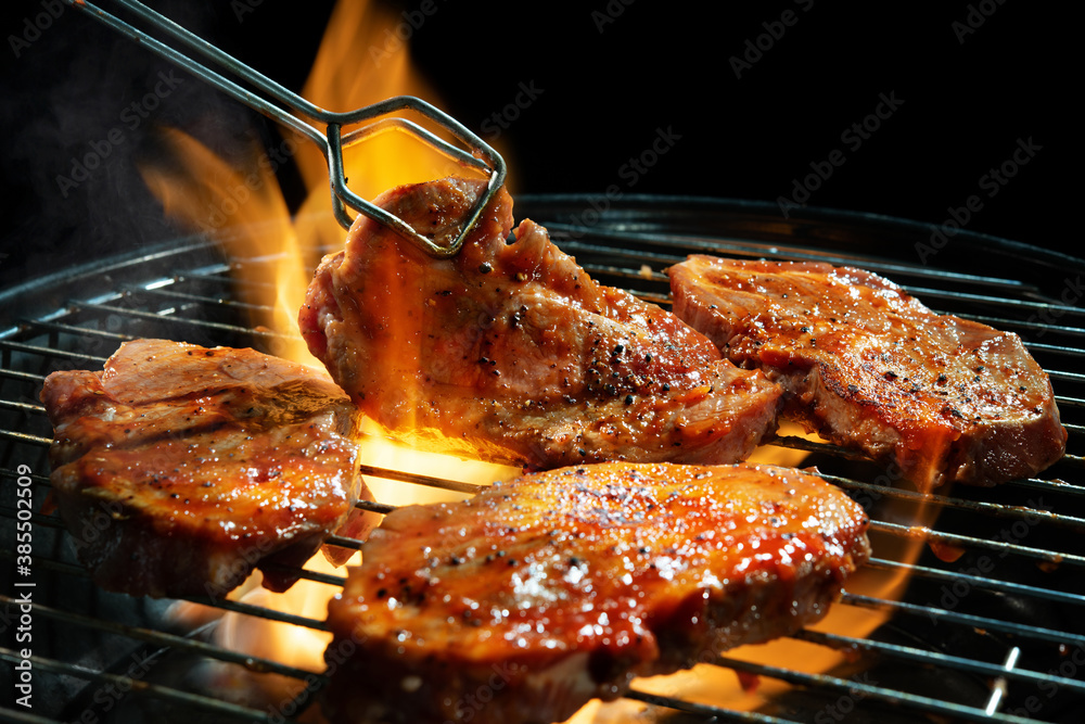 Poster marinated pork steaks on barbecue grill