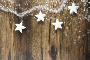 New Year and Christmas background. Snowflakes, stars and snow on a wooden background. Copy space.