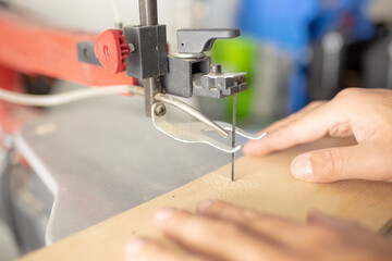 Man at work, Working man, cuts a piece of wood and constructs  objects. Hand work and bricolage concept. Craftsman works in his laboratory with an electric saw. Close up shot of hands