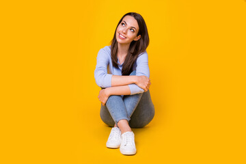 Portrait of her she nice attractive lovely pretty dreamy cheerful cheery girl sitting on floor creating new solution copy space clue guess isolated bright vivid shine vibrant yellow color background
