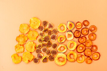 slices of dried persimmon, peach, plum and figs on a orange background. dried fruits. eco.