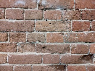 Old brick wall, horizontal shot. Background of old red vintage dirty brick wall with peeling plaster, texture