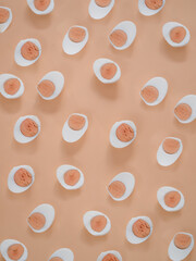 Boiled half cut eggs pattern on cream background...