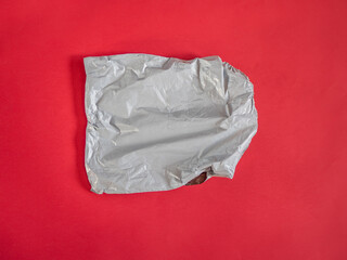 Grey plastic delivery bag on red background