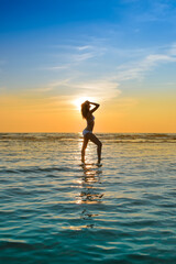 woman in white bikini posing in a sea