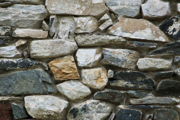 Stone wall texture.
Serbian rural house wall made of natural stones background. Close up on stone wall surface.