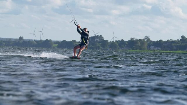 Young kiter catching wind with his kite. Windy day on a coast. Making tricks