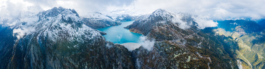 Panorama of arch dam and reservoir lake in snow covered Swiss Alps mountains to produce renewable...