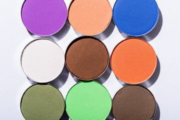 top view of multicolored eyeshadow on white background