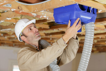 builders working on house ventilation pipes