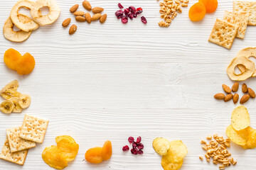 Snacks mix frame top view. Nuts and dried fruits with crackers, copy space
