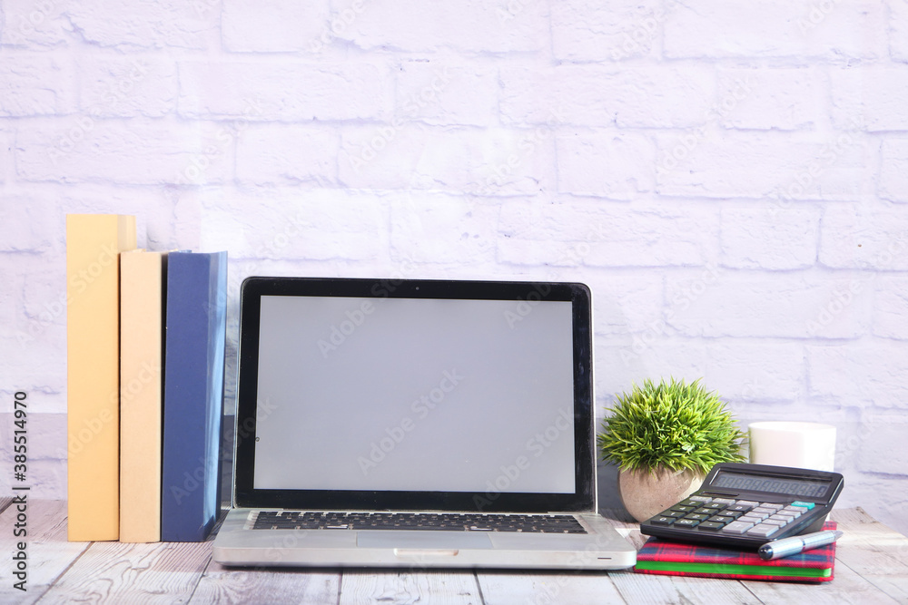 Poster laptop with blank screen on office desk.