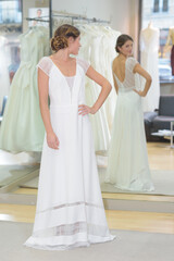 Naklejka premium woman trying wedding dress in boutique