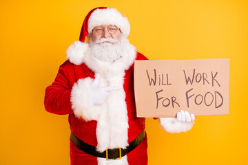 Portrait of his he nice jobless fired serious white-haired Santa holding in hands demonstrating paper card promo will work for food isolated bright vivid shine vibrant yellow color background