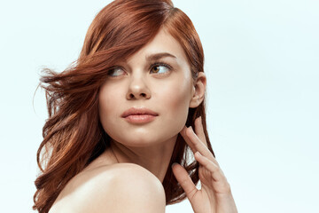 Obraz premium Pretty woman holding hair smile cosmetics lifestyle naked shoulders hairstyle care charm light background