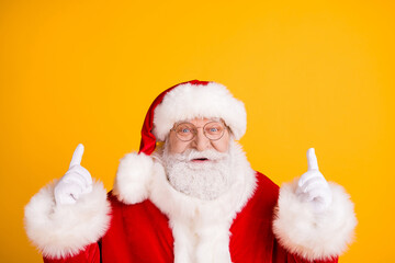 Close up photo jolly holly magic fairy grey beard santa claus indicate x-mas christmas spirit adverts point finger up copyspace wear red headwear cap isolated bright shine color background
