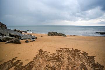 .A sandy beach on the shores of the ocean during stormy weather.