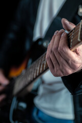 Guitarist hands and guitar strings close up.