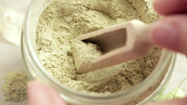 Ayurvedic cosmetic ubtan for face and hair care. Woman's hands make cleansing product of ubtan powder and water and apply cream on skin