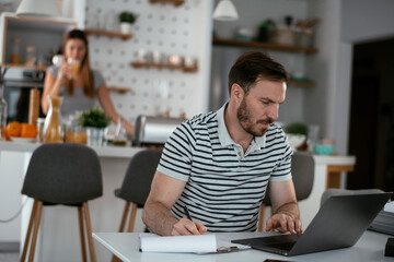 Fototapeta premium Young man working on project. Handsome man working at home.