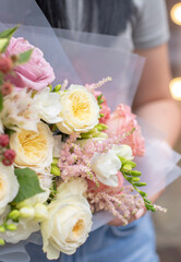 Fresh beautiful flower. Woman holding a big delicate flower bouquet of roses, hydrangea and others wrapped in paper.