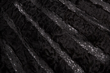 Texture black astrakhan fur skin. Background.