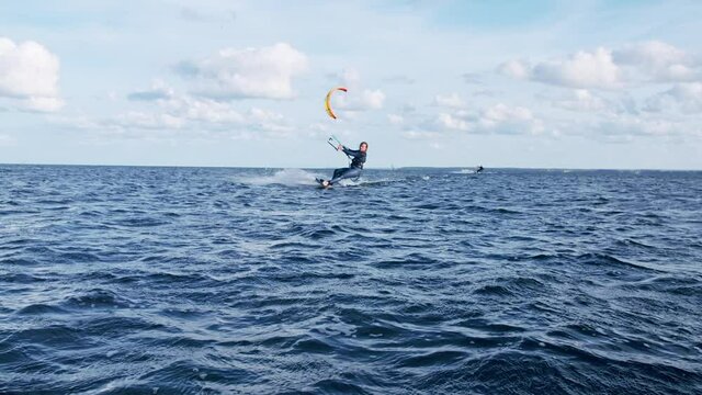 Professional kiter catching wind with his kite. Windy day on a coast