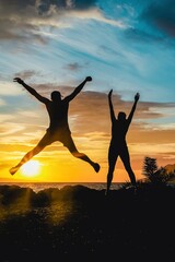 Happy people jumping over sunset, concept having fun, freedom and joy