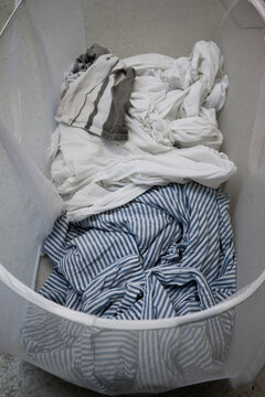 Dirty Bedding Inside Fabric Mesh Laundry Basket Top View