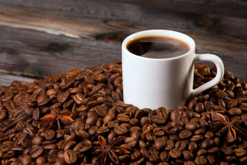 A cup of coffee on the background of coffee beans.