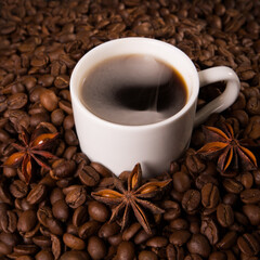 A cup of coffee on the background of coffee beans.