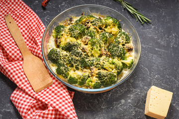 Broccoli cheddar egg casserole in baking dish on black stone background